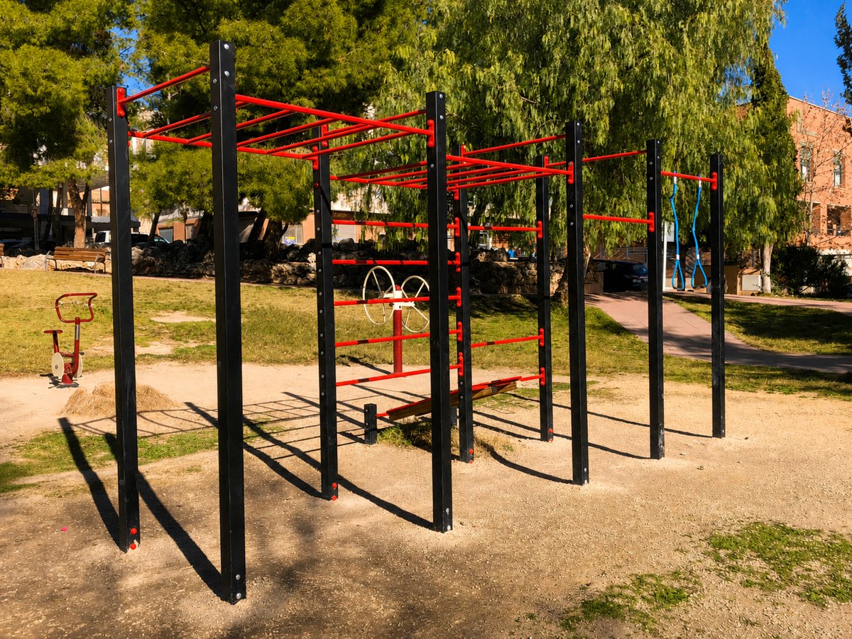 Parque urbano de calistenia con estructura de barras roja y negra